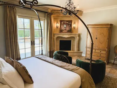 a bedroom with a four poster bed and a fireplace at Villa Arden Hills in Sacramento