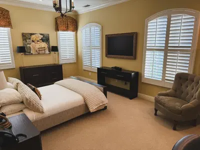 a bedroom with a bed and a tv and a chair at Villa Arden Hills in Sacramento