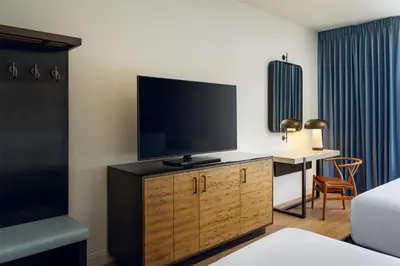 a hotel room with a flat screen tv on a wooden cabinet at Martis Valley Lodge, Tapestry Collection by Hilton in Truckee