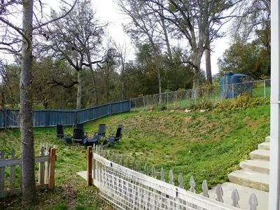 a fence with two chairs on top of a hill at Charming Downstairs Unit in Oakhurst
