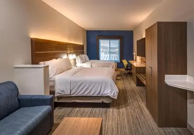 a hotel room with a large bed and a couch at Holiday Inn Express Reno Airport by IHG in Reno