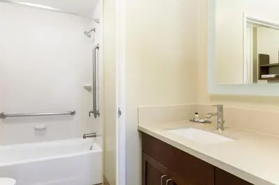 a bathroom with a sink and a tub and a mirror at Staybridge Suites Reno Nevada by IHG in Reno