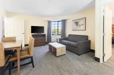 a living room with a couch and a chair and a desk at Staybridge Suites Reno Nevada by IHG in Reno