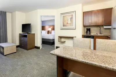 a hotel room with a kitchen and a bedroom at Staybridge Suites Reno Nevada by IHG in Reno