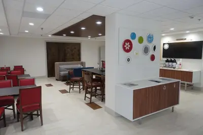 a waiting room with tables and chairs and a tv at Holiday Inn Express & Suites Brentwood in Brentwood