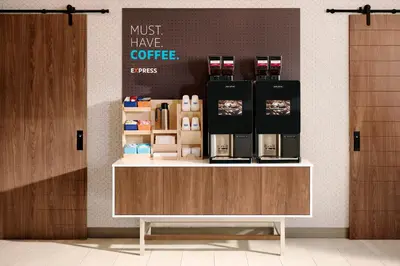 a coffee shop with a counter with a coffee maker on it at Holiday Inn Express Fresno South by IHG in Fresno