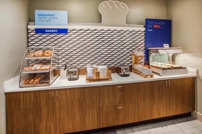 a bakery with a counter with donuts on it at Holiday Inn Express Fresno River Park Highway 41 by IHG in Fresno