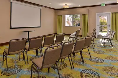 a conference room with chairs and a screen at Holiday Inn Express Fresno River Park Highway 41 by IHG in Fresno