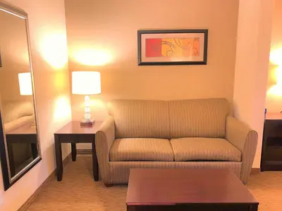 a living room with a couch and a table at Holiday Inn Express Fresno Northwest - Herndon by IHG in Herndon