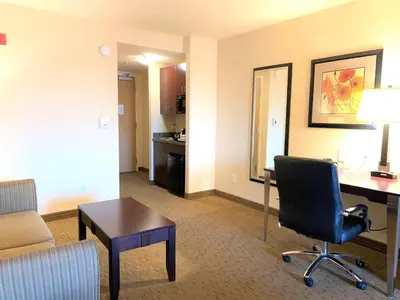 a hotel room with a desk and a chair at Holiday Inn Express Fresno Northwest - Herndon by IHG in Herndon