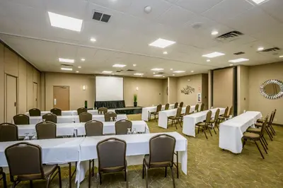 a conference room with tables and chairs and a whiteboard at Wyndham Garden Fresno Yosemite Airport in Fresno