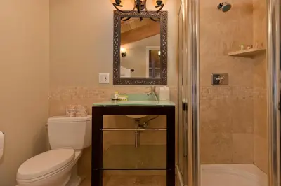 a bathroom with a toilet and a sink and a mirror at Village Treehouse #1 in Mammoth Lakes