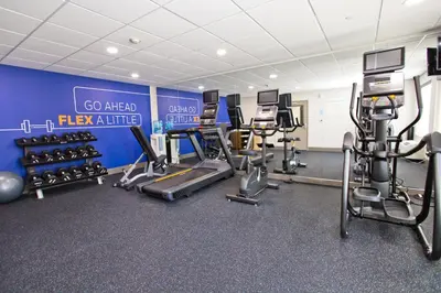 a gym with cardio equipment and a blue wall at Holiday Inn Express & Suites Sacramento NE Cal Expo by IHG in Sacramento