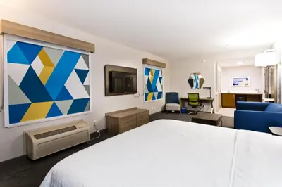 a hotel room with a bed and a living room at Holiday Inn Express & Suites Sacramento NE Cal Expo by IHG in Sacramento