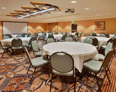 a conference room with tables and chairs and a whiteboard at Holiday Inn Express & Suites Sacramento NE Cal Expo by IHG in Sacramento