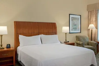 a hotel room with a bed and a chair at Hilton Garden Inn Sacramento Elk Grove in Elk Grove