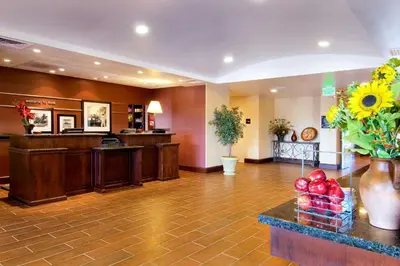 a lobby of a hotel with a reception desk and flowers at Hampton Inn & Suites Lodi in Lodi