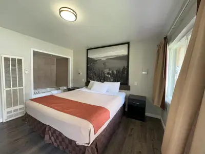 a hotel room with a bed and a painting on the wall at Alpine Inn & Spa in South Lake Tahoe