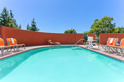 a swimming pool with lounge chairs and a swimming pool at Holiday Inn Express Elk Grove West I-5 by IHG in Elk Grove