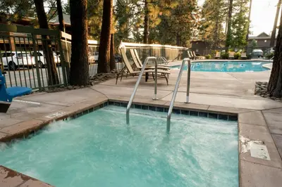 a swimming pool with two chairs and a table at Holiday Inn Express South Lake Tahoe by IHG in South Lake Tahoe