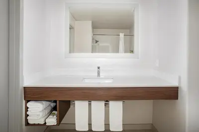 a bathroom with a sink and a mirror at Holiday Inn Express & Suites Yosemite Park Area by IHG in Chowchilla