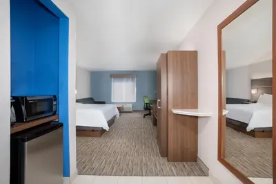 a hotel room with two beds and a flat screen tv at Holiday Inn Express & Suites Yosemite Park Area by IHG in Chowchilla