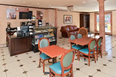 a restaurant with tables and chairs and a counter at Holiday Inn Rancho Cordova - Northeast Sacramento by IHG in Rancho Cordova