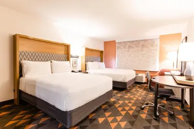 a hotel room with two beds and a desk at Holiday Inn Rancho Cordova - Northeast Sacramento by IHG in Rancho Cordova