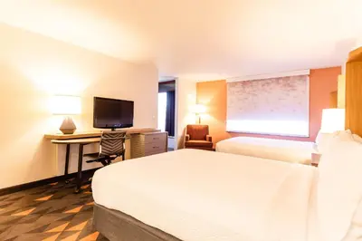 a hotel room with a bed and a desk with a television at Holiday Inn Rancho Cordova - Northeast Sacramento by IHG in Rancho Cordova
