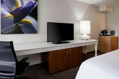 a hotel room with a desk with a tv and a chair at Hilton Garden Inn Folsom in Folsom