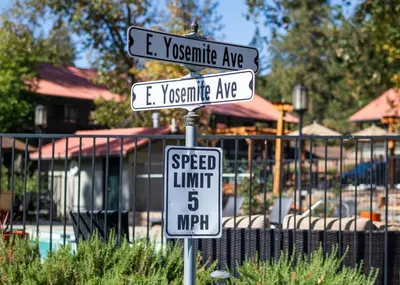 two street signs on a pole with a speed limit sign at Yosemite Westgate Lodge in Groveland