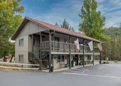 a large building with flags in a parking lot at Yosemite Westgate Lodge in Groveland