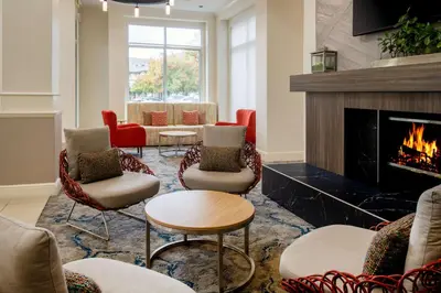 a living room with chairs and a fireplace at Hilton Garden Inn Roseville in Roseville