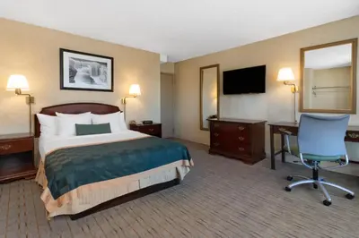 a hotel room with a bed and a desk and a television at Ramada by Wyndham Reno Hotel & Casino in Reno