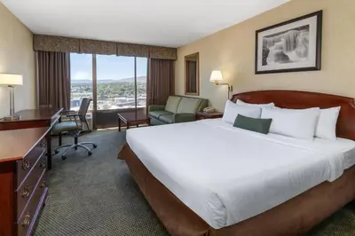 a hotel room with a large bed and a desk at Ramada by Wyndham Reno Hotel & Casino in Reno