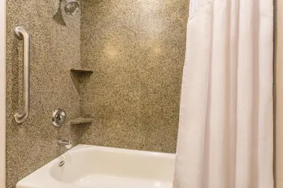 a bathroom with a white shower curtain and a tub at Holiday Inn Express Hotel & Suites Manteca by IHG in Manteca