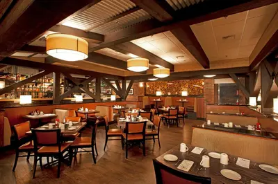 a restaurant with tables and chairs and a bar at Holiday Inn Auburn by IHG in Auburn