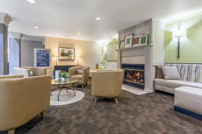 a living room with couches and a fireplace at Holiday Inn Auburn by IHG in Auburn