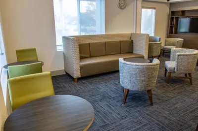 a waiting room with a couch and chairs at Holiday Inn Express Hotel & Suites Roseville - Galleria Area by IHG in Roseville