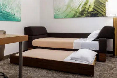 a room with three beds and a chair at SpringHill Suites by Marriott Sacramento Roseville in Roseville