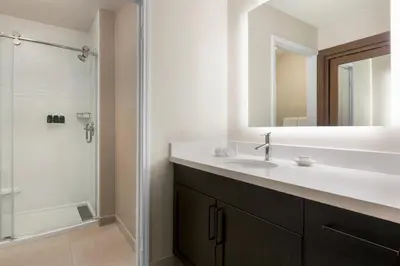 a bathroom with a sink and a shower with a mirror at Residence Inn by Marriott Roseville in Roseville