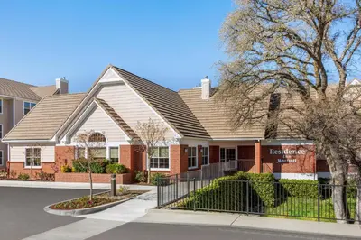 a house with a fence in front of it at Residence Inn by Marriott Roseville in Roseville