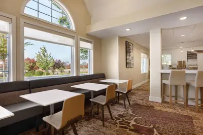 a restaurant with tables and chairs and a large window at Residence Inn Sacramento Folsom in Folsom