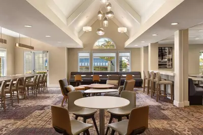 a waiting room with tables and chairs and windows at Residence Inn Sacramento Folsom in Folsom