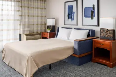 a hotel room with a bed and a television at Courtyard by Marriott Sacramento Folsom in Folsom