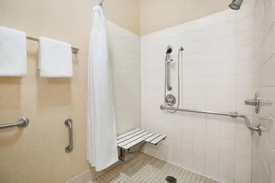 a bathroom with a shower and a bench in it at Courtyard by Marriott Sacramento Folsom in Folsom