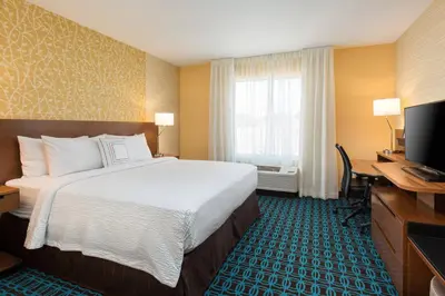 a hotel room with a bed and a desk and a television at Fairfield Inn & Suites by Marriott Sacramento Folsom in Folsom