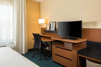 a hotel room with a desk with a television on it at Fairfield Inn & Suites by Marriott Sacramento Folsom in Folsom
