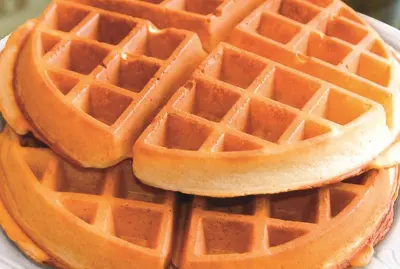 a stack of waffles on a white plate at La Quinta by Wyndham Morgan Hill-San Jose South in Morgan Hill