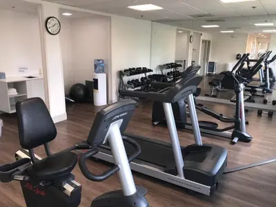 a gym with several tread machines and a clock at Holiday Inn Express & Suites Tracy by IHG in Tracy